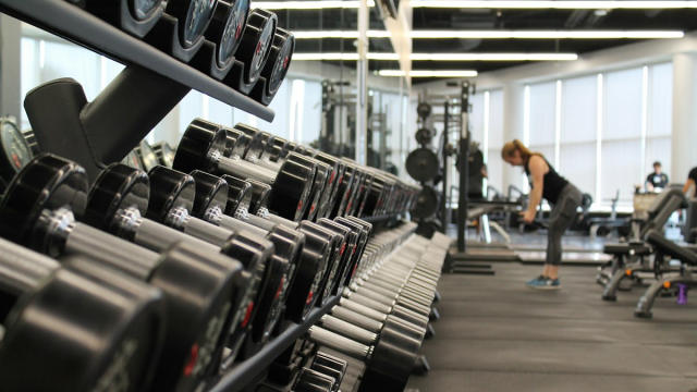 Mujer entrenando en un gimnasio con mancuernas