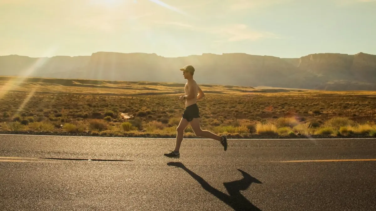 Hombre corriendo por una carretera al atardecer