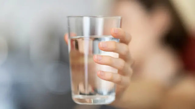 Mano sujetando un vaso de agua