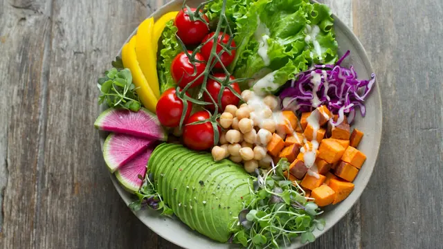 Cuenco de ensalada con aguacate, tomates, garbanzos y verduras
