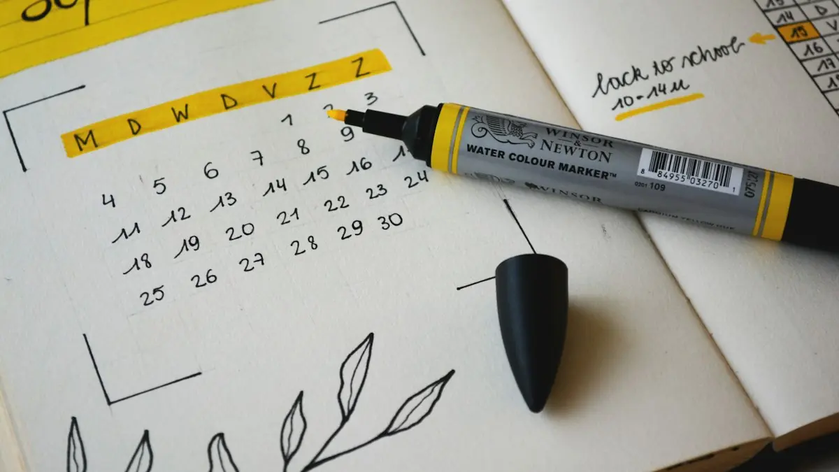 Calendario dibujado a mano en un cuaderno con un rotulador encima