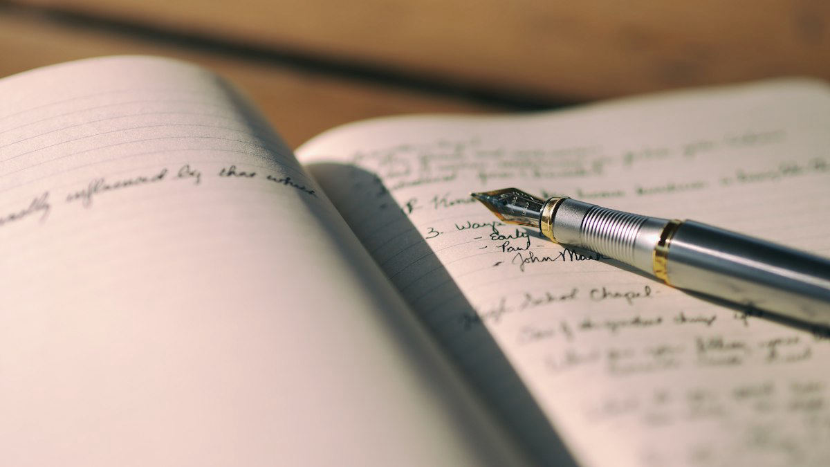 Pluma sobre una libreta con texto escrito a mano