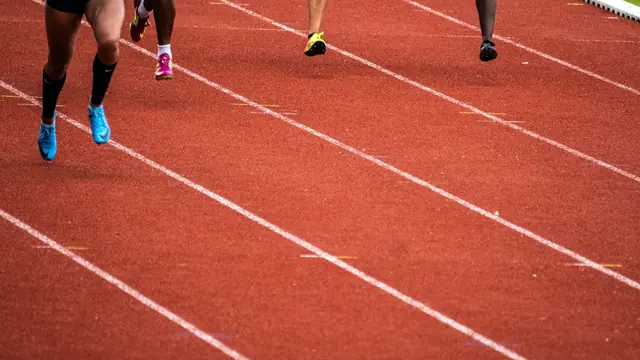 Piernas de varios corredores en una pista de atletismo