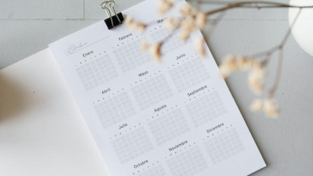 Calendario anual en papel sobre una mesa blanca